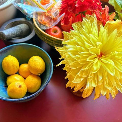 Lemons in a cobalt bowl beside a yellow dahlia