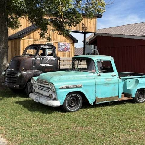 A faded turquoise Chevrolet Apache pickup by a barn